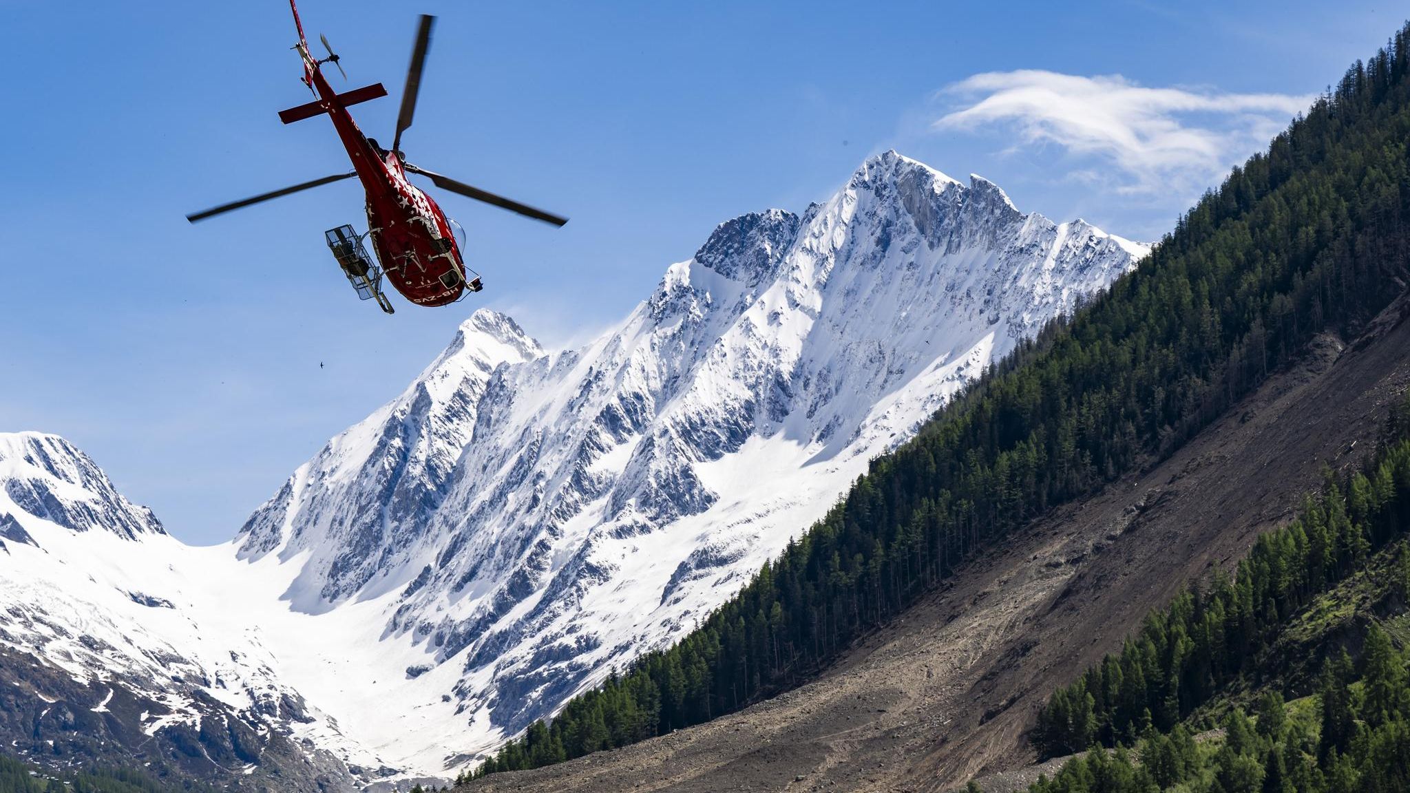 Ein Hubschrauber über dem Geröllfeld im Schweizer Lötschental nach dem Bergsturz von Blatten