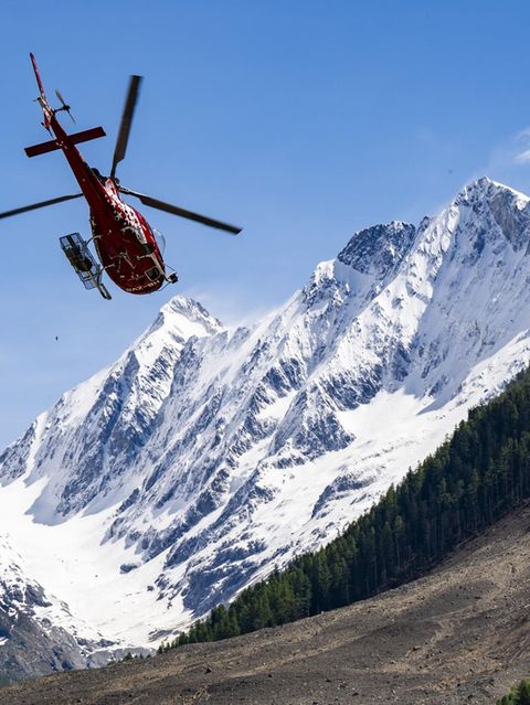 Ein Hubschrauber über dem Geröllfeld im Schweizer Lötschental nach dem Bergsturz von Blatten