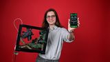 ein junger Mann mit einem Terrarium und einem Smartphone