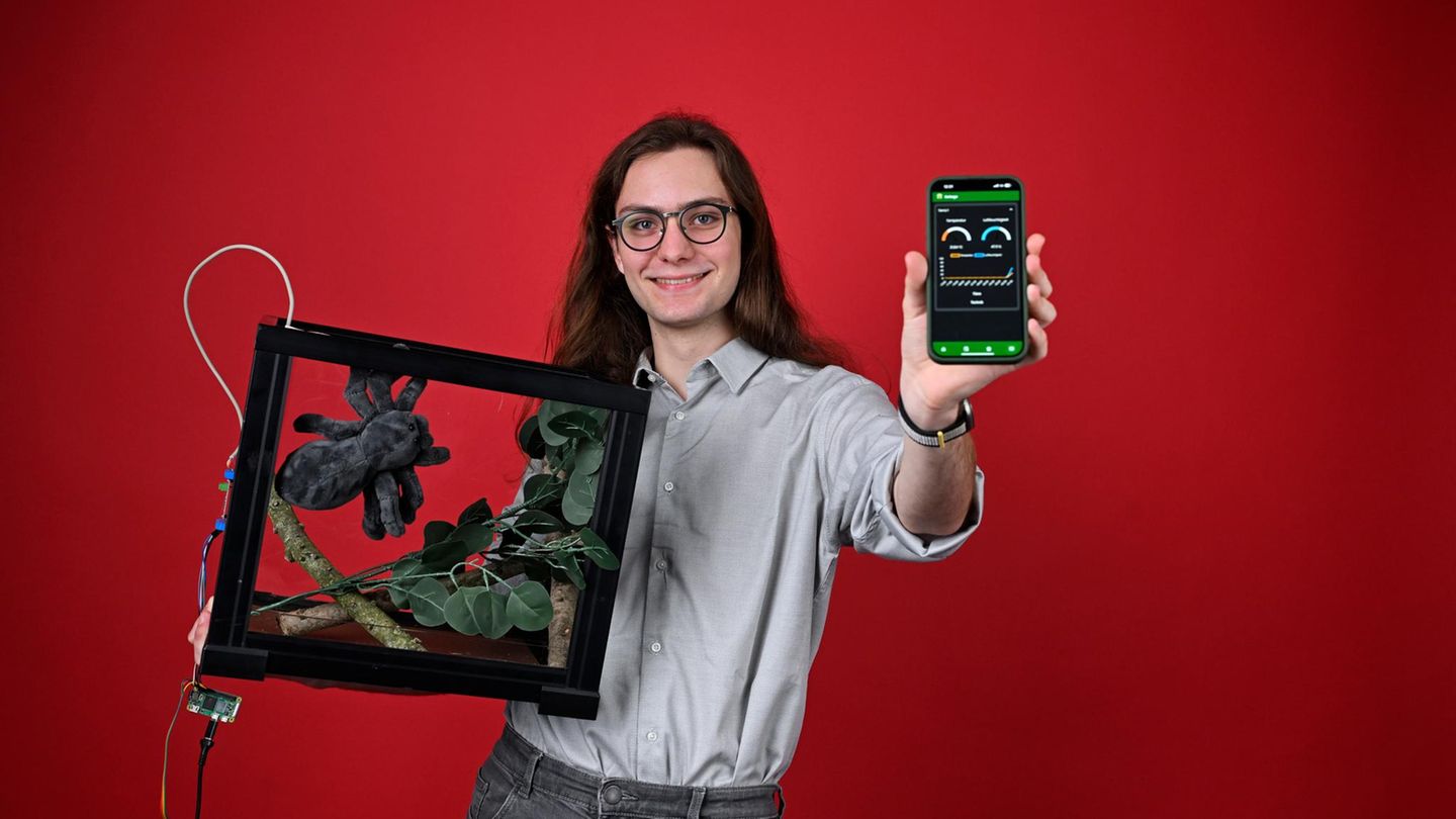 ein junger Mann mit einem Terrarium und einem Smartphone