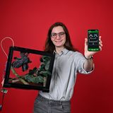 ein junger Mann mit einem Terrarium und einem Smartphone