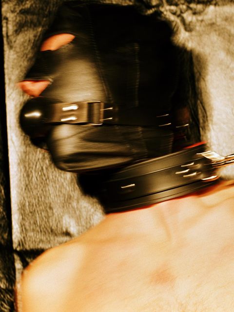 Junger Mann trägt Ledermaske und Leine, wohl ein Fetisch
