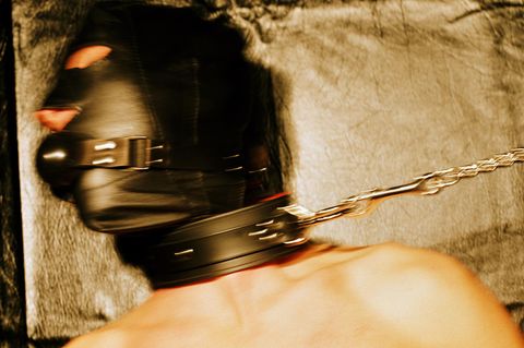 Junger Mann trägt Ledermaske und Leine, wohl ein Fetisch