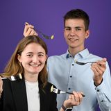 ein Mädchen und ein Junge halten ein Gabel mit einer Kapsel