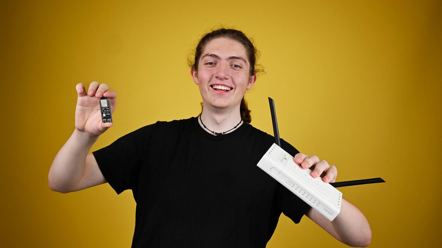 ein junger Mann hält in der Hand einen Computerchip