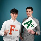 zwei junge Männer halten die Noten A und F in den Händen