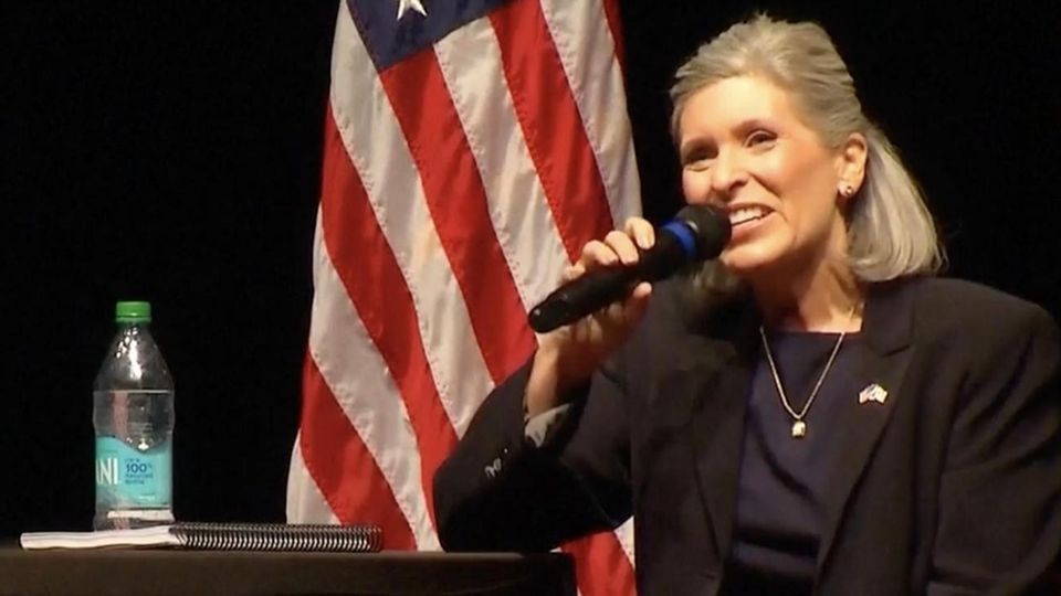 US-Senatorin schockt mit Aussage zu Medicaid-Kürzung – und legt auf Friedhof nach Joni Ernst sitzt auf einer Bühne bei einer Bürgerversammlung in Iowa und redet in ein Mikrofon