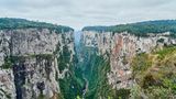 170 Kilometer nordöstlich von Porto Alegre, inmitten des brasilianischen Bundesstaates Rio Grande do Sul, liegt der 800 Meter tiefe Itaimbezinho Canyon. Entlang seiner bizarr geformten Felsklippen, liegen versteckte Hochmoore und die einzigartige Vegetation des angrenzenden Regenwalds bietet vielen Lebewesen ein Zuhause. Genau aus diesem Grund wird die Schlucht seit 1959 durch den Nationalpark Aparados da Serra geschützt. Die Wanderungen zu den Aussichtspunkten sind anstrengend und erfordern Schwindelfreiheit, da viele der Trampelpfade steile Klippen passieren und die Wanderwege wetterbedingt oft rutschig sind
