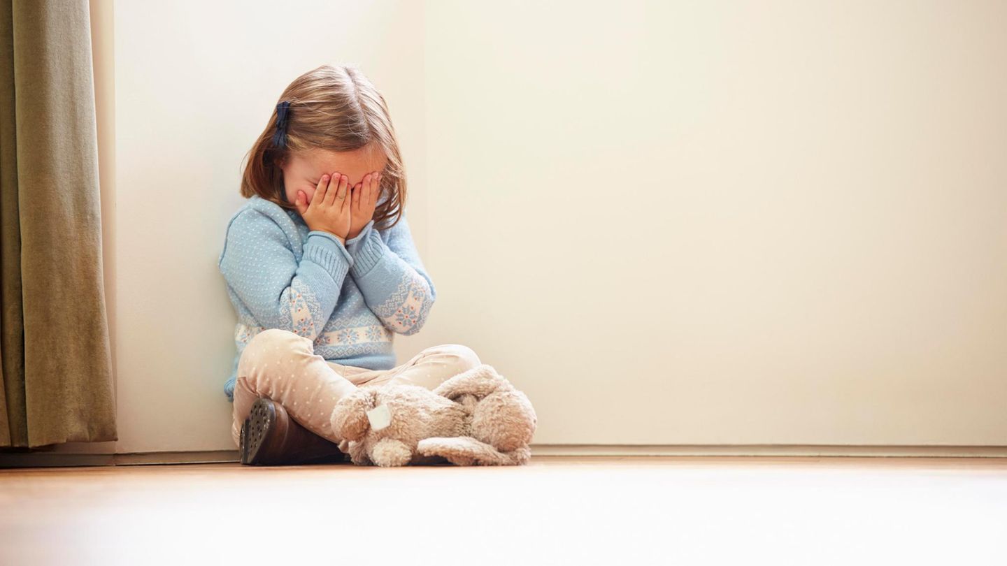 Kindesmissbrauch: Kleines Kind sitzt auf dem Boden und hält sich die Augen zu