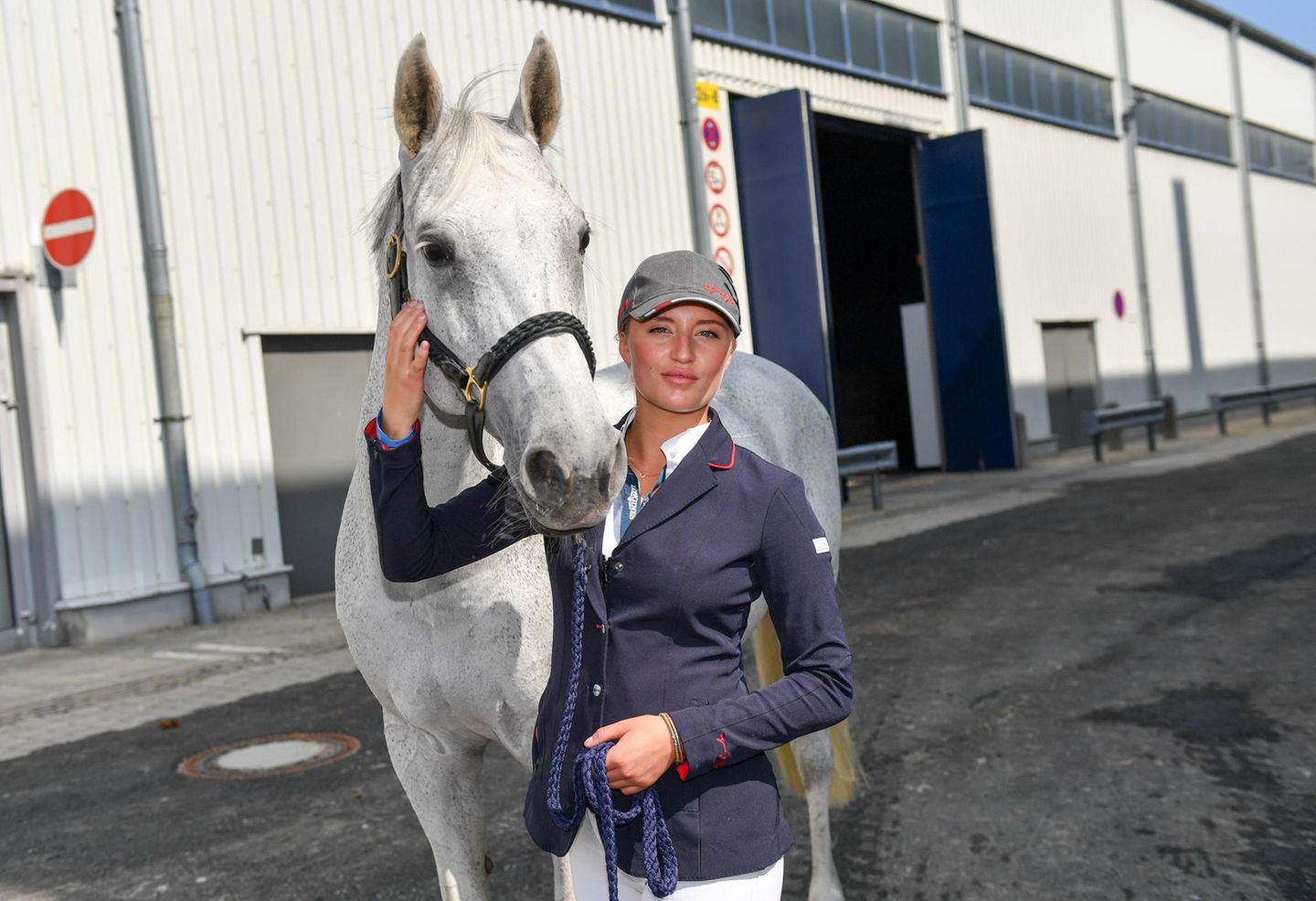 Luna Marie Schweiger und ihr Pferd Tikeur stehen vor einem Gebäude. Luna Marie Schweiger und ihr Pferd Tikeur stehen vor einem Gebäude.