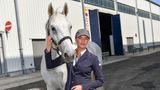 Luna Marie Schweiger und ihr Pferd Tikeur stehen vor einem Gebäude.
