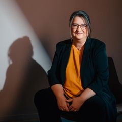 Otto CEO Petra Scharner-Wolff sitzt auf einem Stuhl. An der Wand erkennt man ihren Schatten.