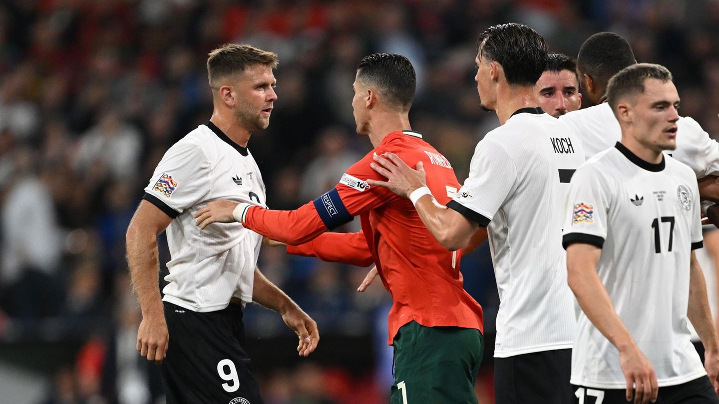 Deutschlands Niclas Füllkrug (l) wird bei einer Rangelei im Nations-League-Spiel von Portugals Cristiano Ronaldo beruhigt