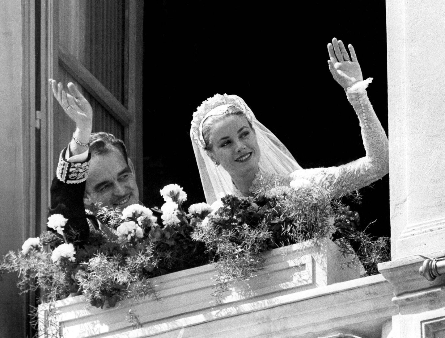 Fürst Rainier und Grace Kelly, nun seine Fürstin, winken nach ihrer Trauung vom Schlossbalkon