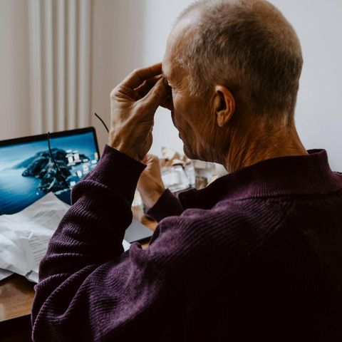 Rente: Mann sitzt am Laptop und greift sich an den Kopf