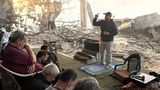 Viele Gläubige sitzen in den Ruinen einer Moschee