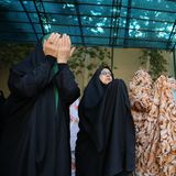 Frauen stehen nebeneinander im Gebet