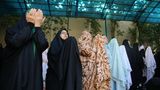 Frauen stehen nebeneinander im Gebet