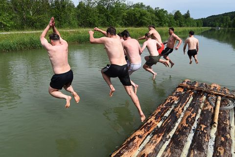 Männer springen in ihrer Freizeit in Wasser