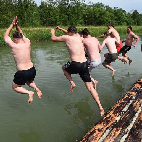 Männer springen in ihrer Freizeit in Wasser