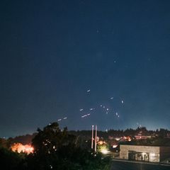 Leuchtspurmunition der Luftabwehr der Ukraine zieht während eines russischen Luftangriffes Spuren über Kiews Himmel