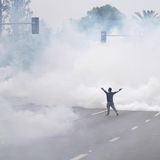 Alleine auf weiter Flur. Diesem Demonstranten scheinen die Tränengaspatronen, die von Sicherheitskräften abgefeuert wurden, nichts auszumachen