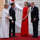 Brigitte Macron erschien dagegen in einem weißen, langen Cape-Kleid von Louis Vuitton