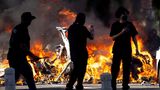 Im Stadtzentrum wurden immer wieder Autos angezündet. Hier passieren Demonstranten die verkohlten Reste mehrerer Fahrzeuge