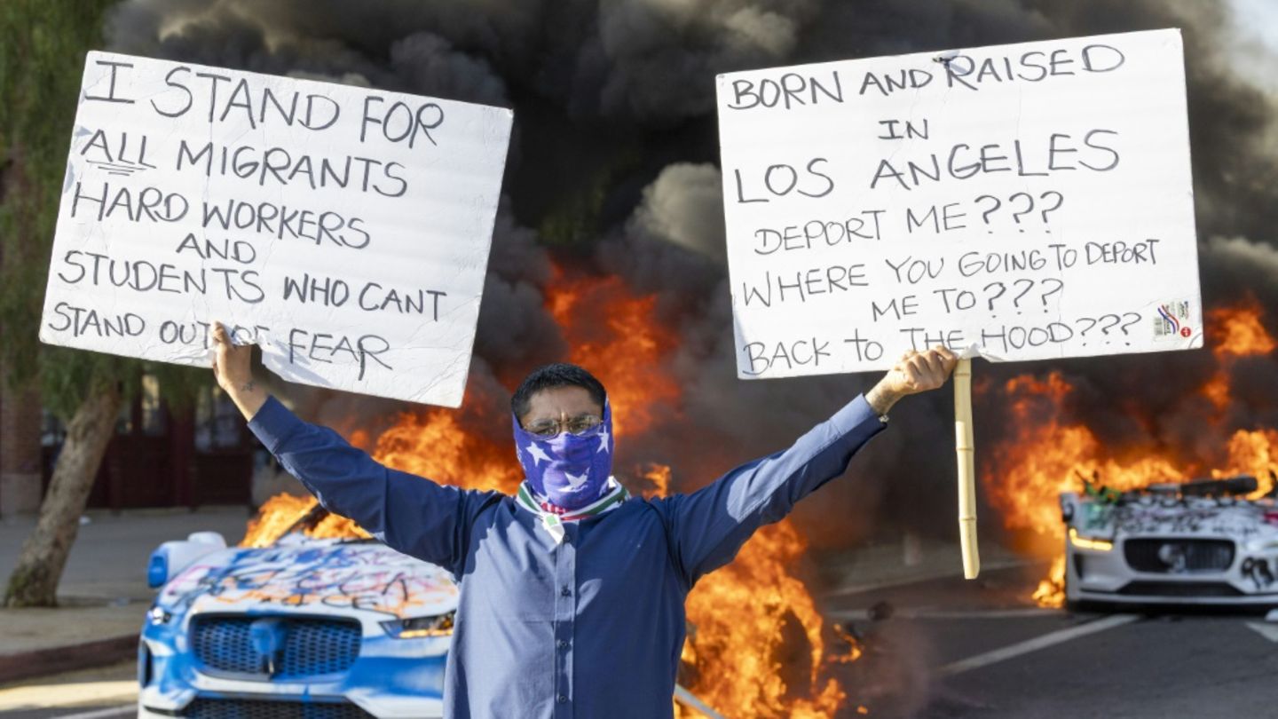 Ein Demonstrant vor brennenden Autos in Los Angeles