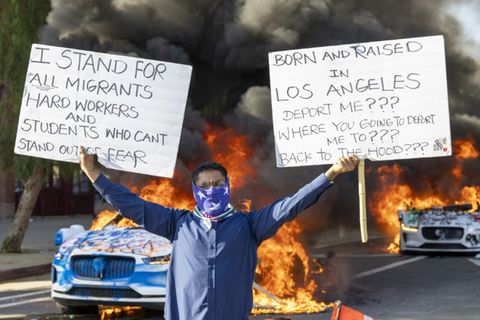 Ein Demonstrant vor brennenden Autos in Los Angeles