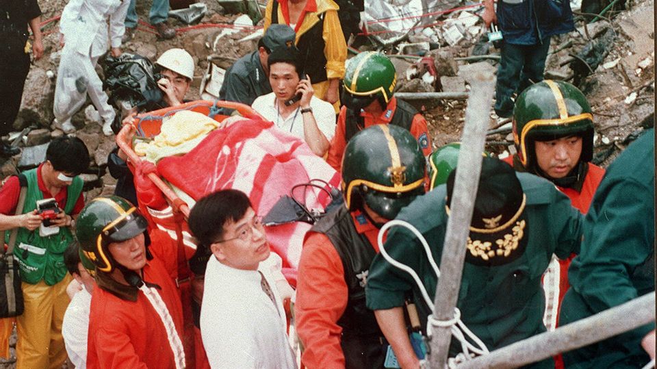 Rettungskräfte tragen Yoo Ji-Hwan auf einer Trage ins Freie. Die damals 19-Jährige überlebte zwölf Tage in den Trümmern Rettungskräfte tragen Yoo Ji-Hwan auf einer Trage ins Freie. Die damals 19-Jährige überlebte zwölf Tage in den Trümmern