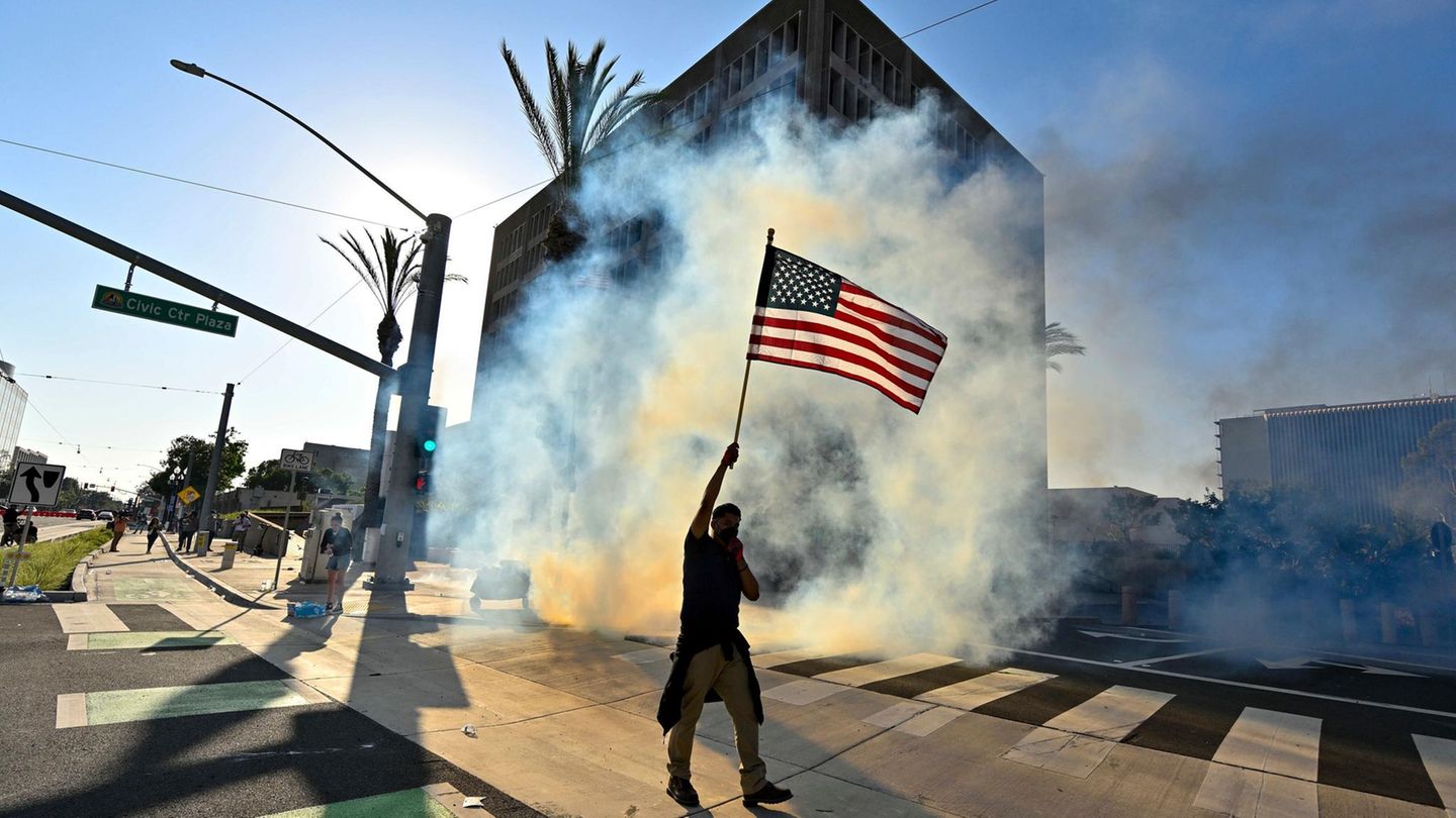 In Los Angeles zieht ein Demonstrant mit US-Flagge durch die Straße