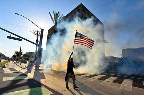 In Los Angeles zieht ein Demonstrant mit US-Flagge durch die Straße
