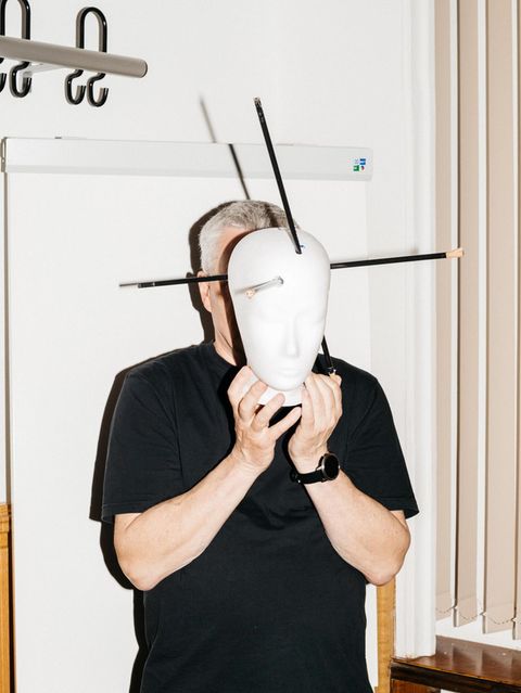 Fred Zack hält sich ein Kopfmodell mit Markierungen von Pfeilverletzungen vors Gesicht
