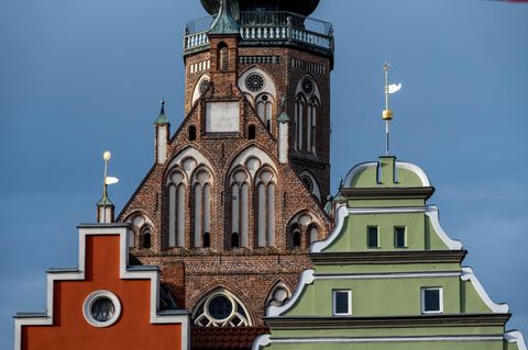 Ein Kirchturm und zwei bunte Giebel in Greifswald, Mecklenburg-Vorpommern