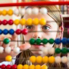 Mathe: Mädchen sitzt vor Rechenschieber