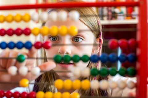 Mathe: Mädchen sitzt vor Rechenschieber