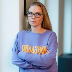 Tatjana Kiel lehnt mit verschränkten Armen gegen einer Wand
