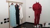 Roter Ski Anzug neben einer Klamottenstange mit weiteren Kleidern