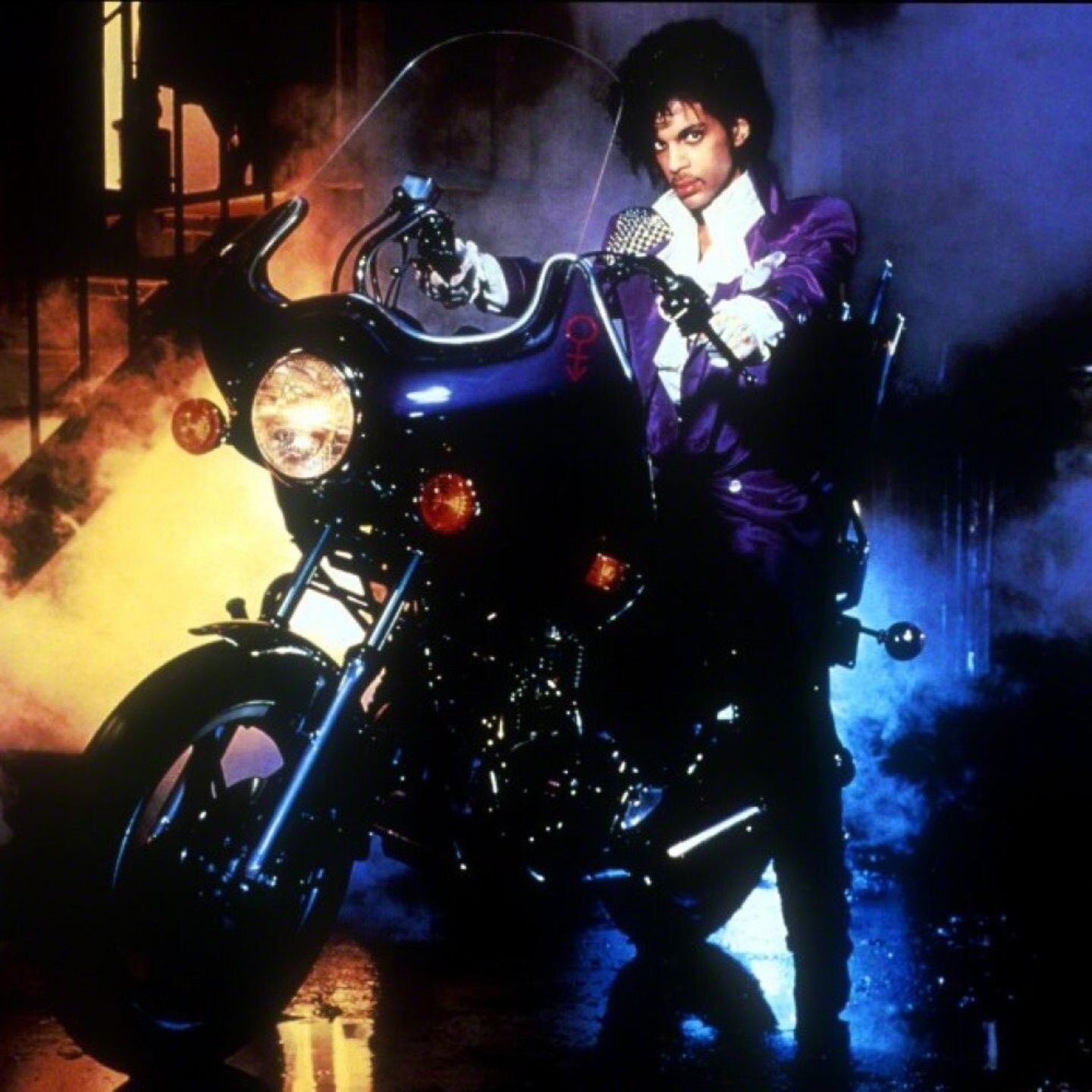 Prince im Film "Purple Rain" im lilafarbenen Anzug auf einer Harley Davidson