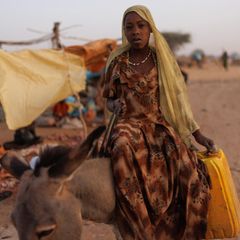 Ein Kind sitzt auf einem Esel in einem Flüchtlingslager im Sudan – Symbolbild UNHCR