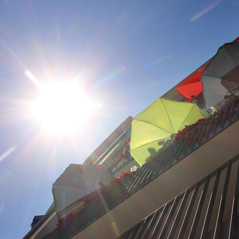 Symbolbild Hitze: Sonnenschirme auf einem Balkon