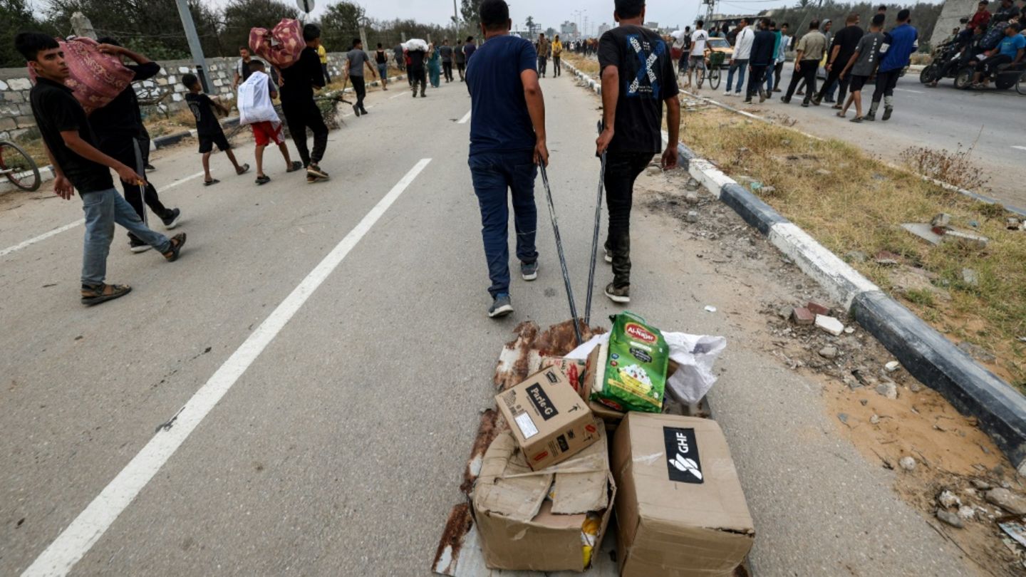 Menschen im Zentrum des Gazastreifens ziehen GHF-Pakete