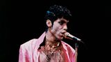 Prince mit dem Wort "Slave" – Sklave – auf der Wange am Mikrofon