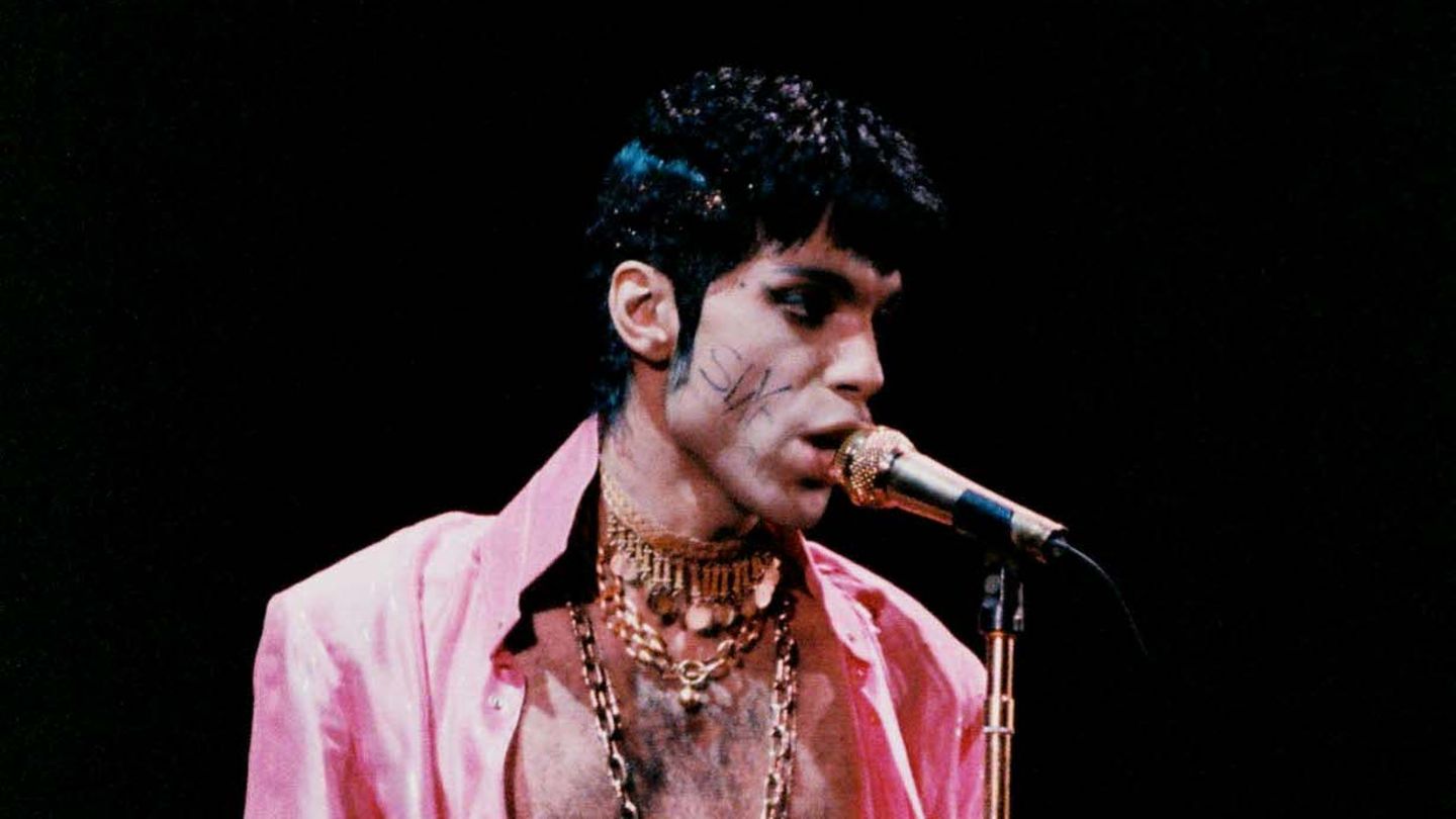 Prince mit dem Wort "Slave" – Sklave – auf der Wange am Mikrofon