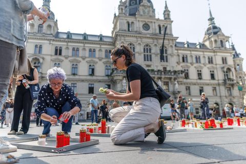 Nach dem Amoklauf: Zwei Frauen legen Kerzen in Gedenken an die Toten ab