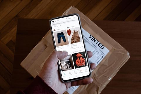 Auf einem Handybildschirm ist die Vinted-App geöffnet, jemand sucht Secondhand Mode
