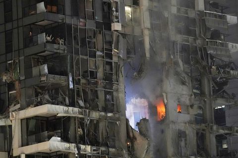 Feuer und Rauch steigen aus einem zerstörten Gebäude in Tel Aviv auf,