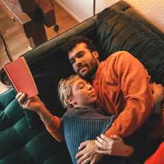 ein Paar liegt auf der Couch und kuschelt