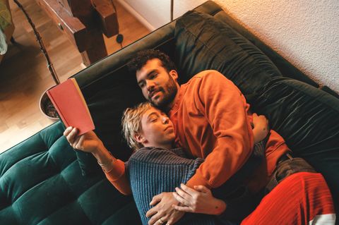 ein Paar liegt auf der Couch und kuschelt